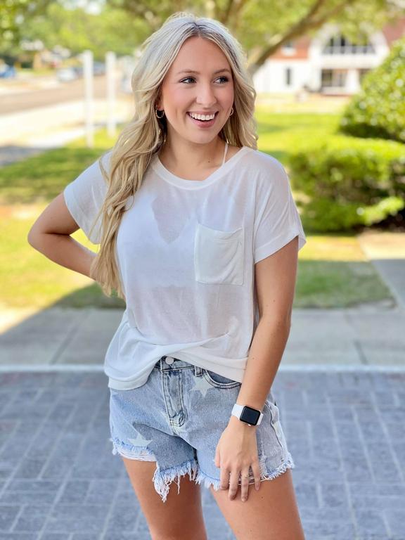  woman wearing a basic white top with jean shorts